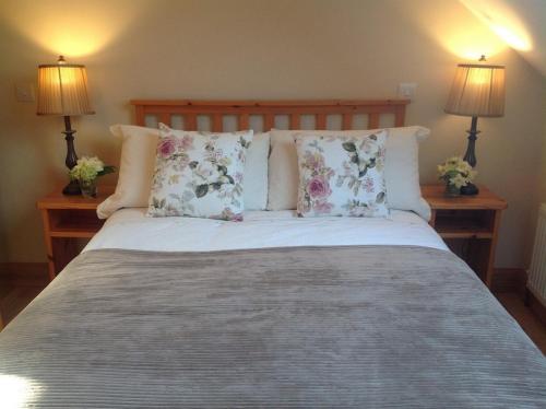 ein Schlafzimmer mit einem großen Bett mit Kissen und zwei Lampen in der Unterkunft 4 bedroom holiday home overlooking the sea in Connemara in Rossaveel