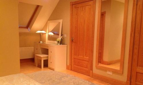 Zimmer mit einer Tür und einem Schreibtisch mit einem Spiegel in der Unterkunft 4 bedroom holiday home overlooking the sea in Connemara in Rossaveel
