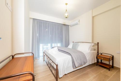 a bedroom with a bed and a table and a window at IAIRA in Athens