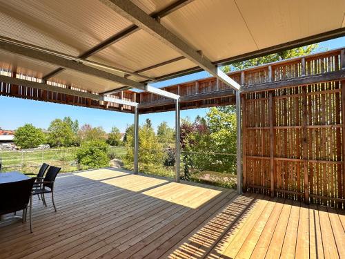 a screened porch with a table and chairs on a wooden deck at Paradies in Bad Radkersburg