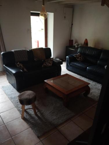 a living room with two black couches and a coffee table at L'ECUREUIL in Loc-Envel