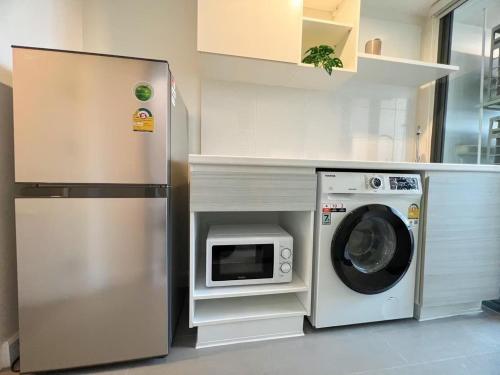 a kitchen with a washing machine and a refrigerator at Metro sky prachachuen in Bang Su
