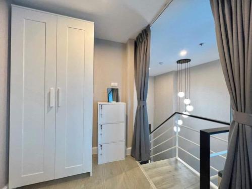 a room with a white cabinet and a refrigerator at Metro sky prachachuen in Bang Su