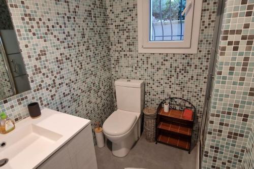Un baño con un inodoro blanco y un lavabo. en Charmante villa tout confort à 10 min de la plage, en Sainte-Maxime