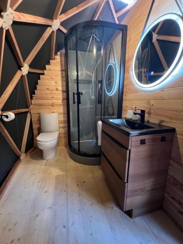 a bathroom with a toilet and a glass shower at Dôme l'Escapade Insolite in Rupt-sur-Moselle