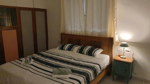 een slaapkamer met een bed en een tafel met een lamp bij Gil's Home of Joy & Serenity in Haifa