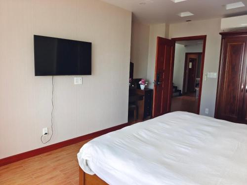 a bedroom with a bed and a flat screen tv on the wall at Sealight Villa and House Phu Quoc in Phu Quoc