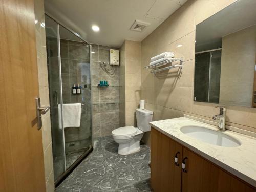 a bathroom with a toilet and a shower and a sink at Pentafield City Residence in Amphoe Phra Khanong