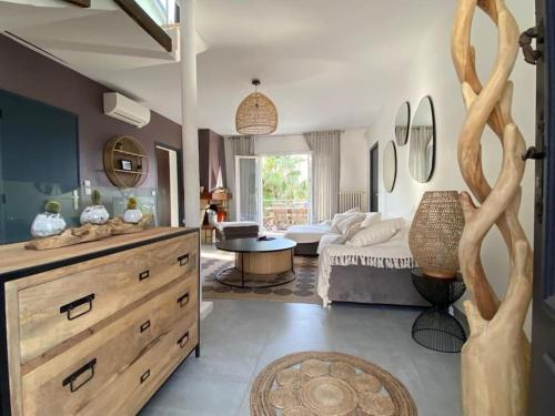 una sala de estar con un sofá y una mesa en Charmante villa tout confort à 10 min de la plage, en Sainte-Maxime