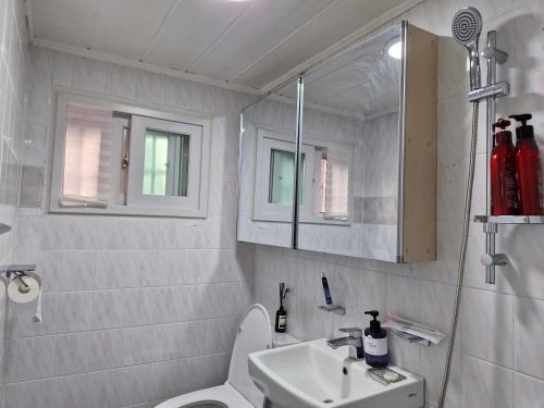 bagno con lavandino, servizi igienici e specchio di Iceblue stay a Seul