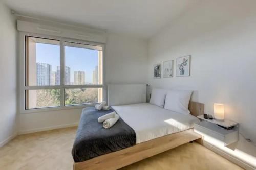 une chambre avec un grand lit et une grande fenêtre dans l'établissement Studio Pablo - 3 min du métro - Idéal duo & bébé, à Bobigny