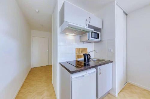 une petite cuisine avec un évier et un micro-ondes dans l'établissement Studio Pablo - 3 min du métro - Idéal duo & bébé, à Bobigny