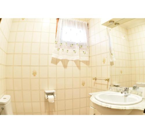 a bathroom with a sink and a toilet and a window at Casa Gilgar Olite in Olite