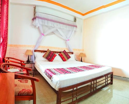 a bedroom with a bed with red curtains and a window at Nguyen Dang Guesthouse in Sa Pa