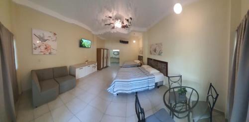 1 dormitorio con 1 cama y 1 sofá en una habitación en Coconut village, en El Zapote