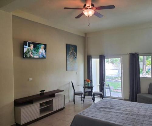 - une chambre avec un lit et un ventilateur de plafond dans l'établissement Coconut village, à El Zapote