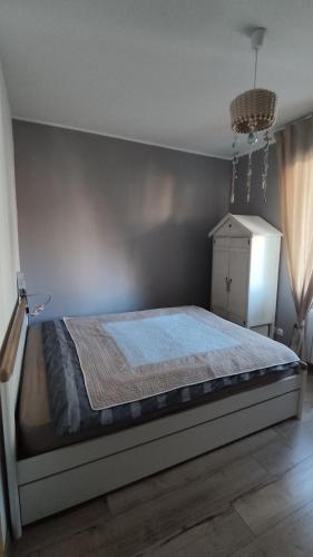 - une chambre avec un lit doté d'une couverture bleue dans l'établissement Villa Primerose, à Andernos-les-Bains