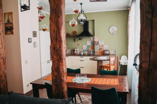 uma cozinha e sala de jantar com uma mesa de madeira em Family apartment in Riga center Free parking em Riga