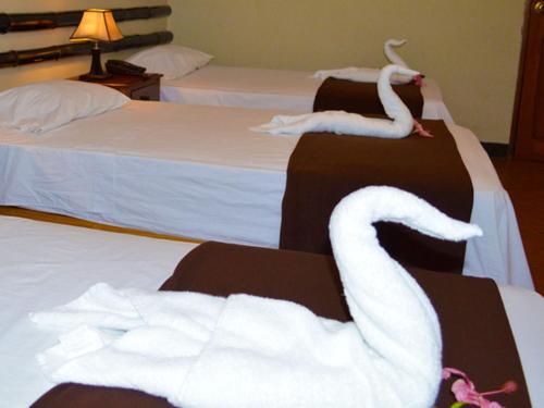 two white swans on two beds in a hotel room at Chanchamayo Inn Hotel in La Merced