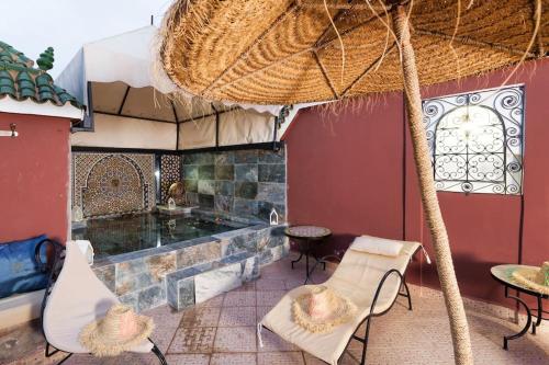 a patio with a fireplace and chairs and a table at Riad Khadoj-Marrakech-Traditional in Marrakesh