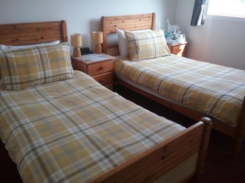 dos camas sentadas una al lado de la otra en un dormitorio en Fairways Guest House, en Newquay