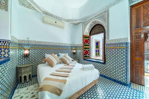 une chambre avec un lit dans une pièce aux carreaux bleus dans l'établissement Riad Khadoj-Marrakech-Traditional, à Marrakech
