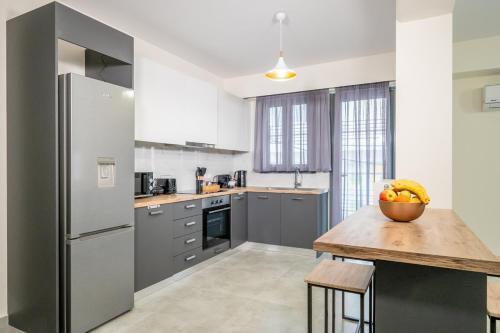 a kitchen with a table with a bowl of fruit on it at IAIRA in Athens