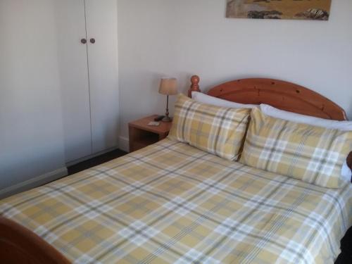 1 dormitorio con 1 cama con manta a cuadros en Fairways Guest House, en Newquay