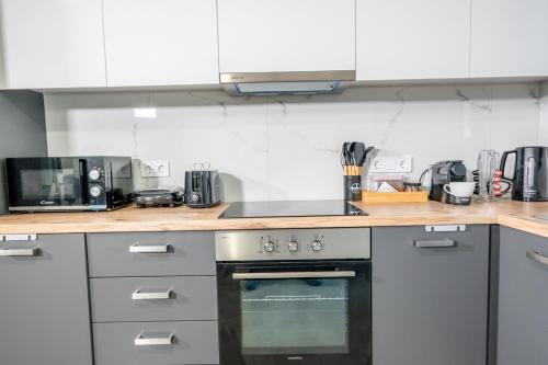 a kitchen with white cabinets and a stove top oven at IAIRA in Athens