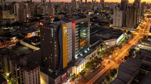 una vista aérea de una ciudad por la noche en HUS Hotel MARINGA en Maringá