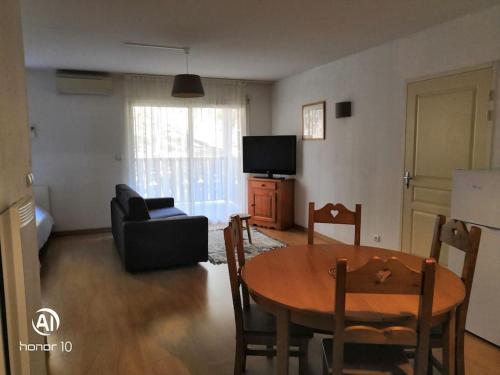 un salon avec une table et un canapé dans l'établissement Grand studio à la montagne, à Ax-les-Thermes