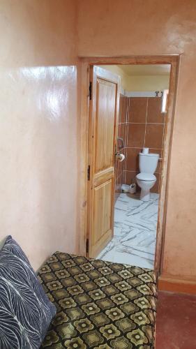 ein Bad mit WC und ein Bett in einem Zimmer in der Unterkunft KASBAH ALTAÏR in El-Kelâa M’Gouna