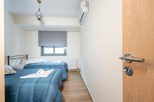 two beds in a room with a blue blanket at IAIRA in Athens