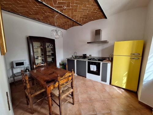 cocina con mesa de madera y nevera amarilla en Agriturismo Frigionaia, en Carmignano