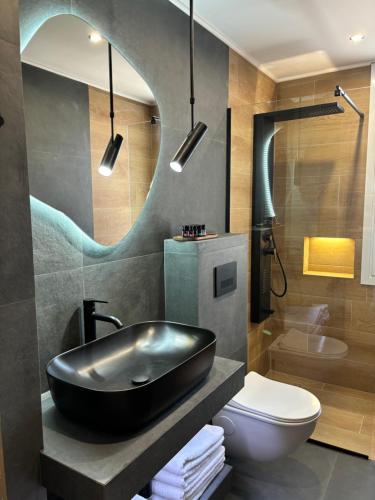 a bathroom with a black sink and a toilet at Caruso Central Apartments in Lefkada