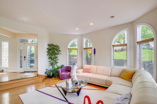 a living room with a couch and a table at Spacious Missouri Retreat with Pool, Gym and Game Room in Chesterfield