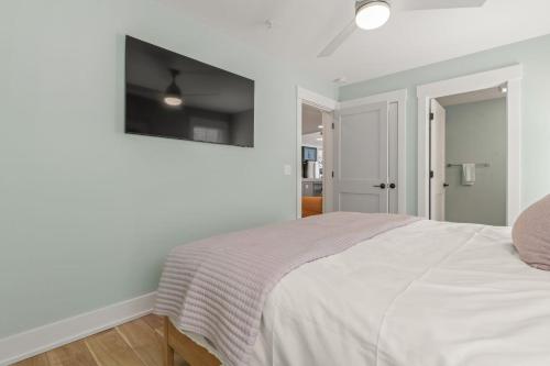 a bedroom with a bed with a television on the wall at Island Enchantment by KEES Vacations in Kill Devil Hills