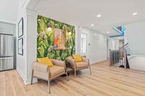 a hallway with two chairs and a painting on a wall at Island Enchantment by KEES Vacations in Kill Devil Hills