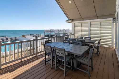 a table and chairs on a balcony with the beach at Island Enchantment by KEES Vacations in Kill Devil Hills