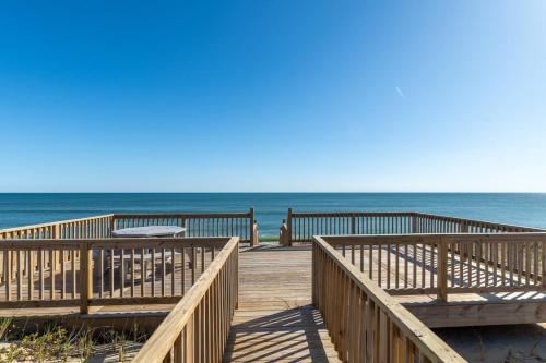 a wooden boardwalk leading to the ocean on a beach at Island Enchantment by KEES Vacations in Kill Devil Hills