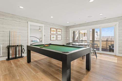 a living room with a pool table in it at Island Enchantment by KEES Vacations in Kill Devil Hills