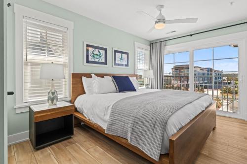 a bedroom with a bed and a large window at Island Enchantment by KEES Vacations in Kill Devil Hills