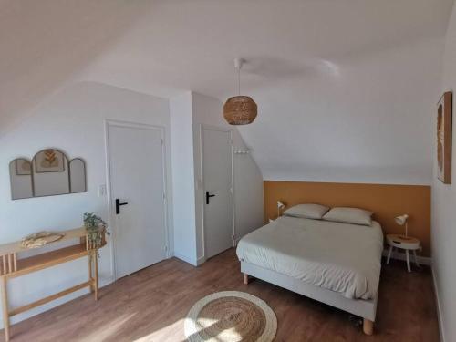 une chambre avec un lit et une table dans une pièce dans l'établissement Le charmant de Lourmel appartement de 30m2 au calme, à Pontivy