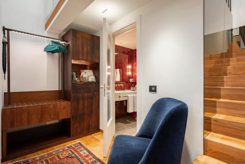 a living room with a blue chair and a staircase at Vico Milano in Milan