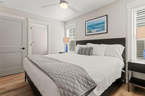a bedroom with a large white bed and a window at Island Enchantment by KEES Vacations in Kill Devil Hills