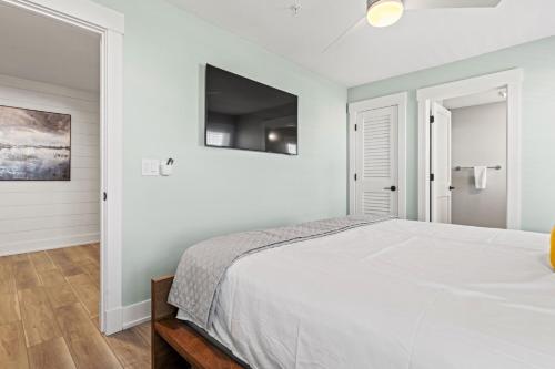 a bedroom with a bed and a flat screen tv at Island Enchantment by KEES Vacations in Kill Devil Hills