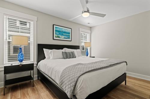 a bedroom with a large bed and two windows at Island Enchantment by KEES Vacations in Kill Devil Hills
