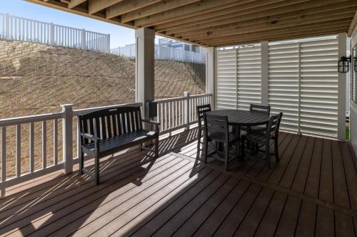 a wooden deck with a table and chairs on it at Island Enchantment by KEES Vacations in Kill Devil Hills