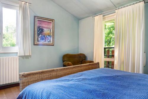 um quarto com uma cama e uma cadeira ao lado de uma janela em Villa della Rocca em Orino