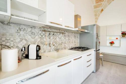 a white kitchen with a sink and a stove at B&b SAN LORENZO in Conversano